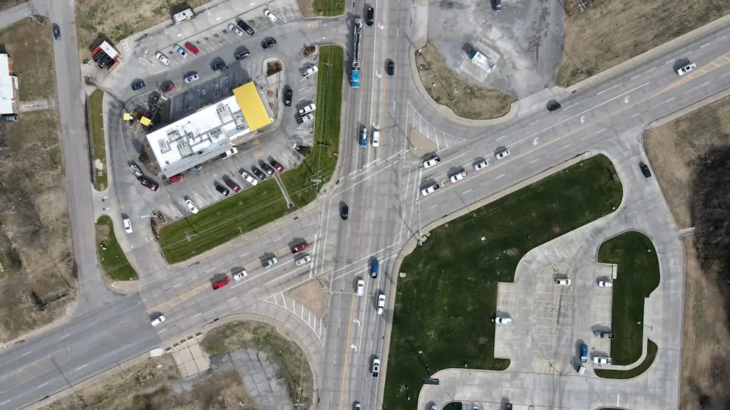Vue aérienne d'un carrefour routier avec marquage au sol et stationnements aux alentours.