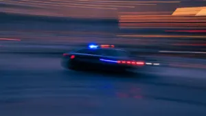 Voiture de police en intervention rapide dans une rue urbaine de nuit.