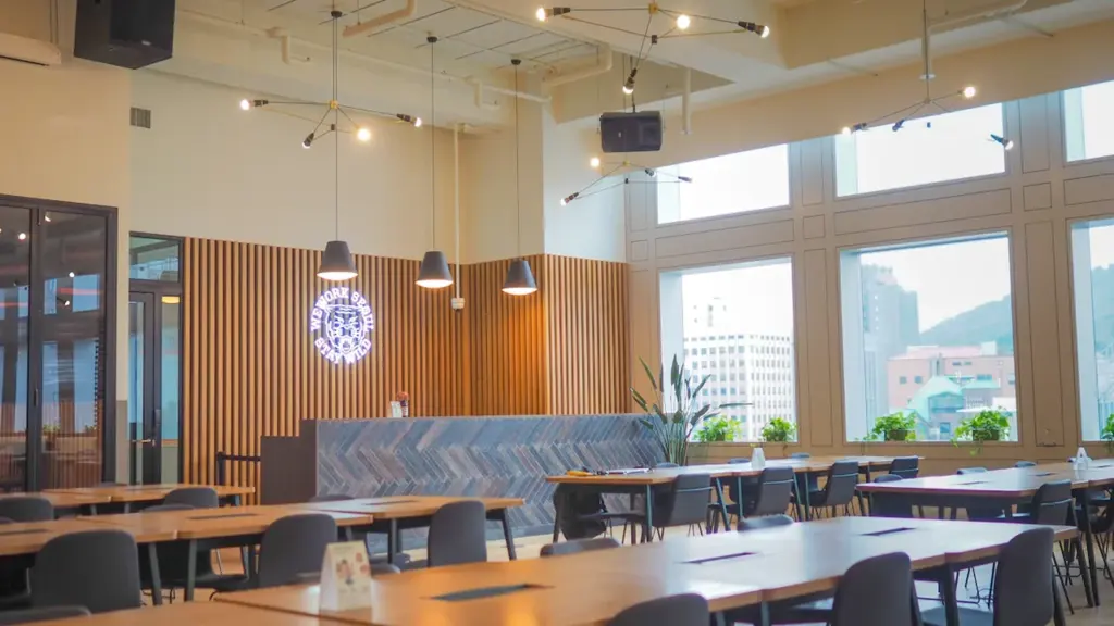 Salle de restauration moderne avec tables en bois et chaises confortables.