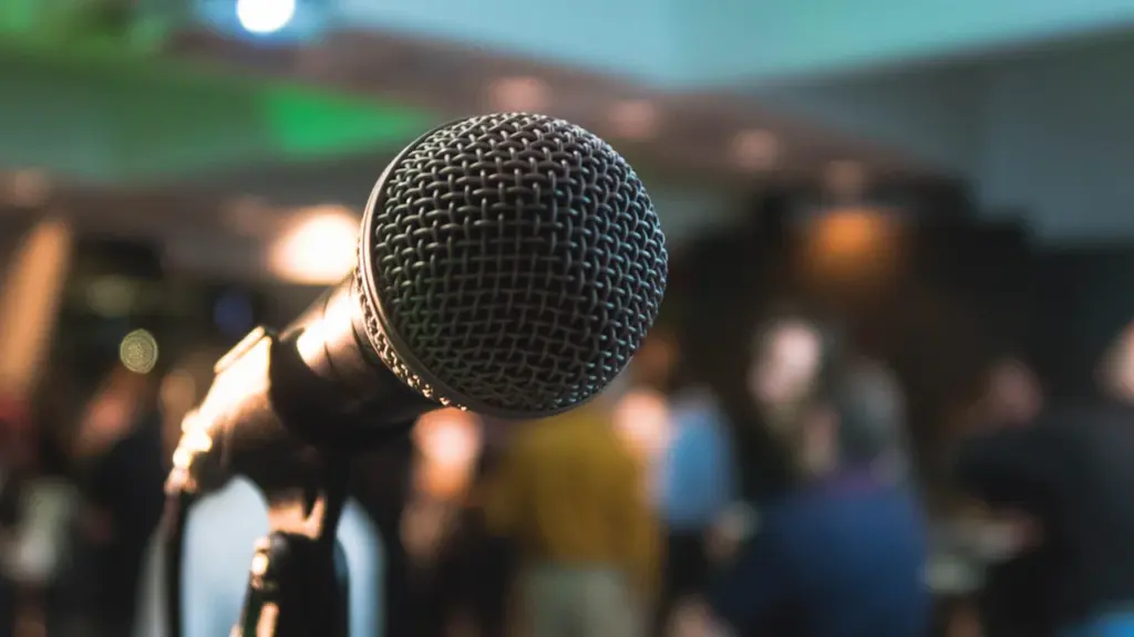 Un microphone sur pied dans une salle de réunion lors d'un échange public.