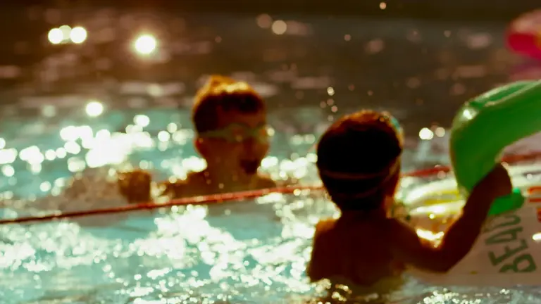 Deux enfants s'amusent dans une piscine lors d'un atelier de sécurité aquatique estivale.