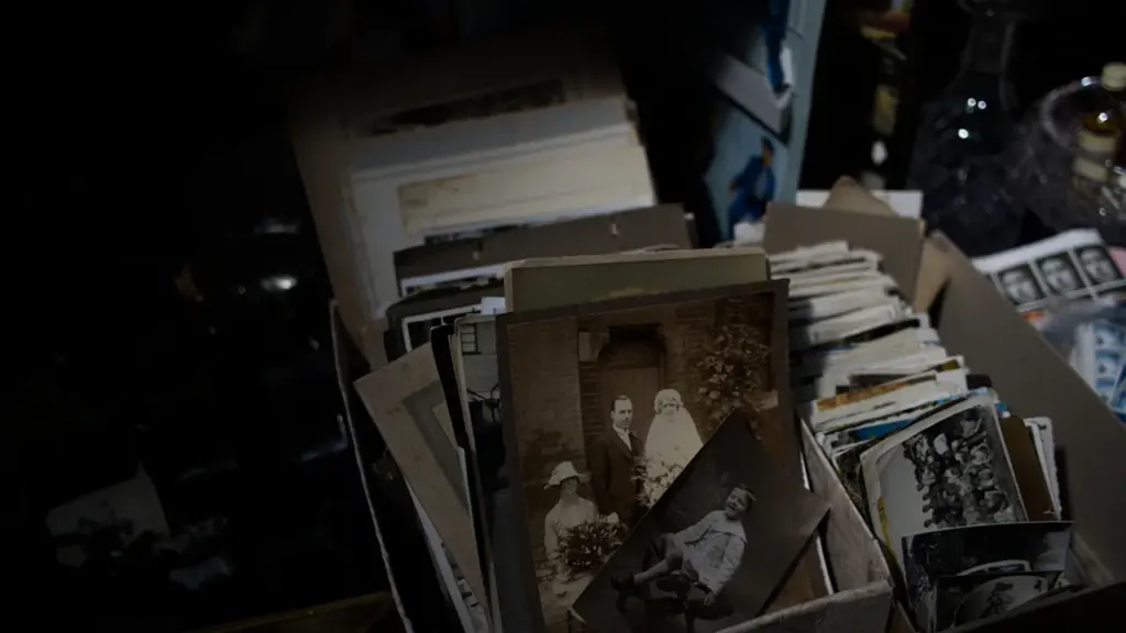 Une boîte remplie de vieilles photographies noir et blanc sur un bureau.