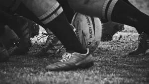 Gros plan en noir et blanc sur un ballon de rugby au sol