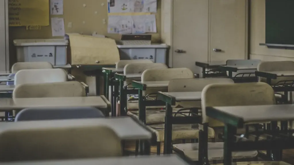 Une salle de classe vide avec des bureaux et des rangements scolaires.