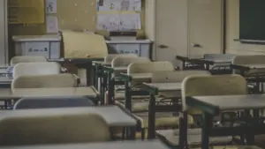 Une salle de classe vide avec des bureaux et des rangements scolaires.