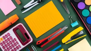 Un ensemble de fournitures scolaires colorées disposées sur un bureau pour la rentrée.