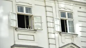 Fenêtres ouvertes sur une façade de bâtiment blanc sous la lumière du jour.