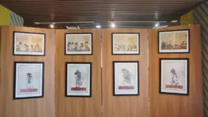 Exposition artistique de tableaux encadrés sur des panneaux en bois dans une galerie lumineuse.