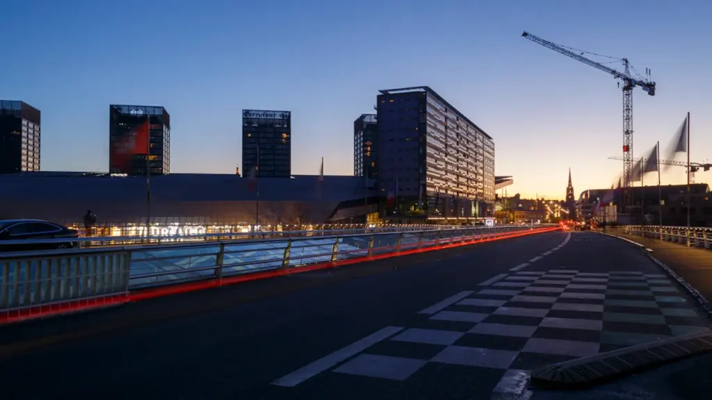 Chantier urbain avec une grue près de bâtiments modernes en soirée.