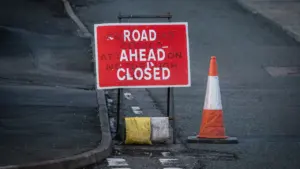 Un panneau de signalisation indiquant une route barrée avec un cône de chantier.
