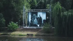 Grand écran de cinéma en plein air installé au bord d'un lac.