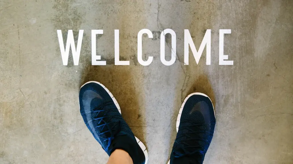 Une vue à la première personne montrant un tapis d'accueil avec inscription Bienvenue.