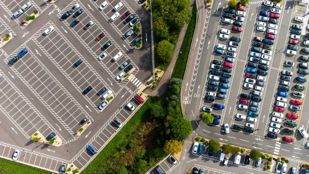 Vue aérienne d'un parking urbain bien organisé avec de nombreuses voitures stationnées.