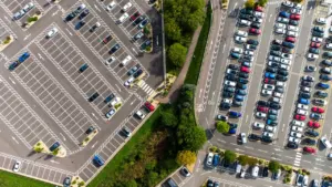Vue aérienne d'un parking urbain bien organisé avec de nombreuses voitures stationnées.