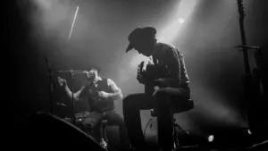 Un musicien en veste noire sur scène lors d'un concert intimiste à Lyon.