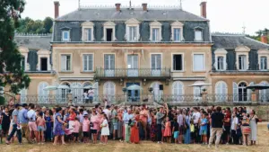 Une foule rassemblée devant un château classique lors d'un événement estival à Dijon.
