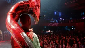 Un musicien jouant du tuba sur scène devant une foule à Grenoble.