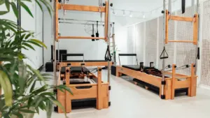 Salle de sport lumineuse équipée de machines de Pilates en bois professionnel.