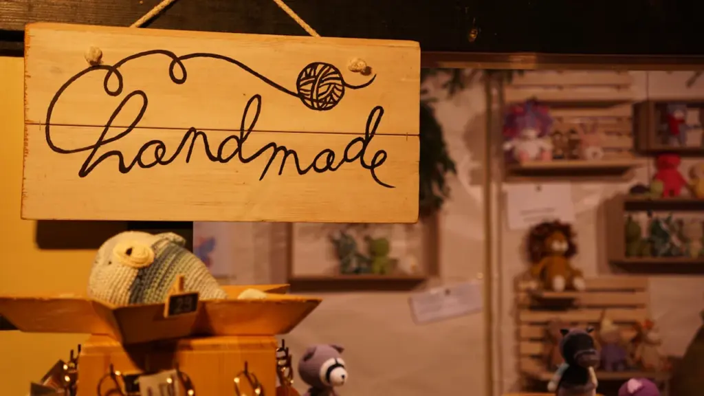 Panneau en bois avec l'inscription 'Handmade' surplombant des articles d'artisanat faits main.