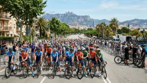 Un grand groupe de cyclistes professionnels attendent sur la route sous un ciel ensoleillé.