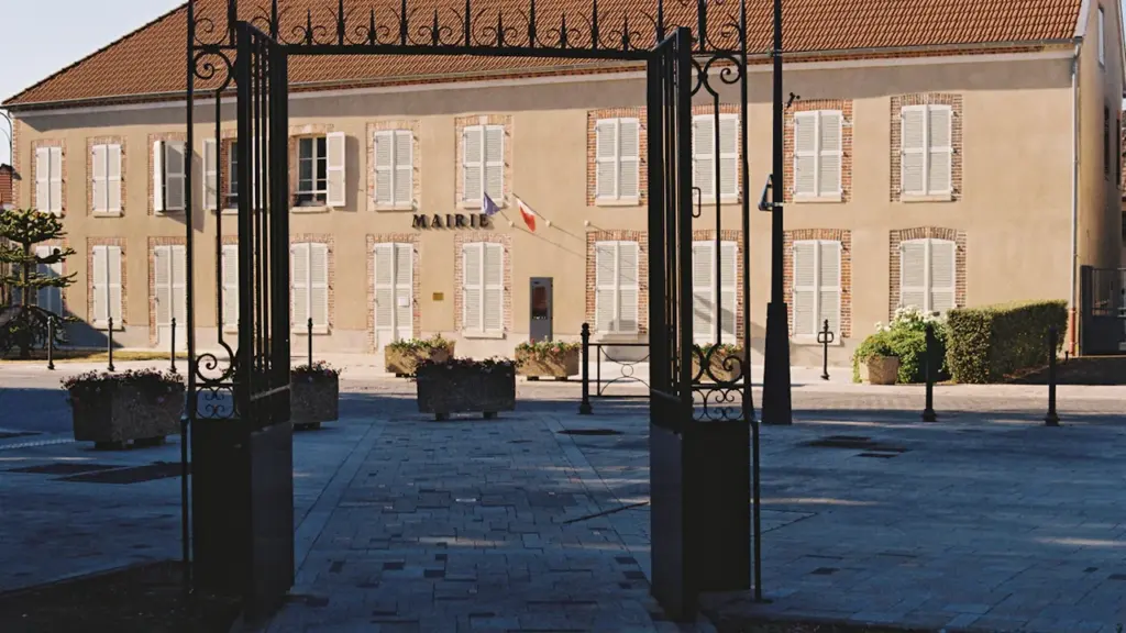 Façade de la mairie de Saint-Junien avec son portail en fer forgé ouvert.