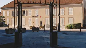 Façade de la mairie de Saint-Junien avec son portail en fer forgé ouvert.