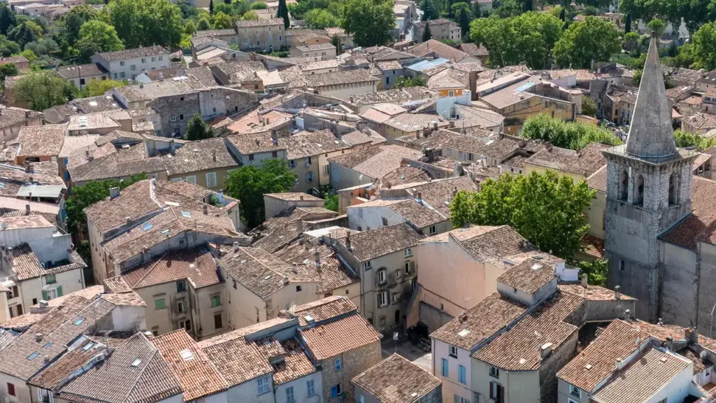 Vue aérienne d'un village provençal typique avec des toits en tuiles et une église ancienne.