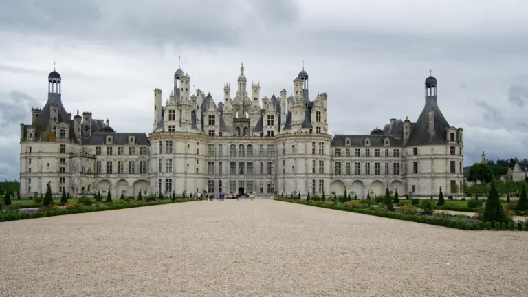 Vue panoramique du majestueux Château de Chambord sous un ciel nuageux français.