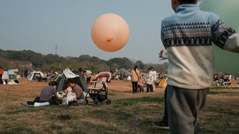 Un enfant joue avec un grand ballon lors d'une fête en plein air.