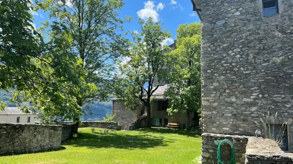 Vue d'une cour intérieure en pierre avec pelouse dans un bâtiment ancien historique.