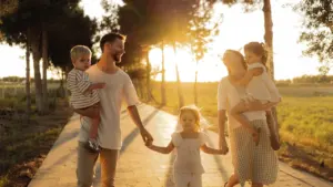 Une famille se promène sur un chemin arboré lors d'une belle journée ensoleillée.