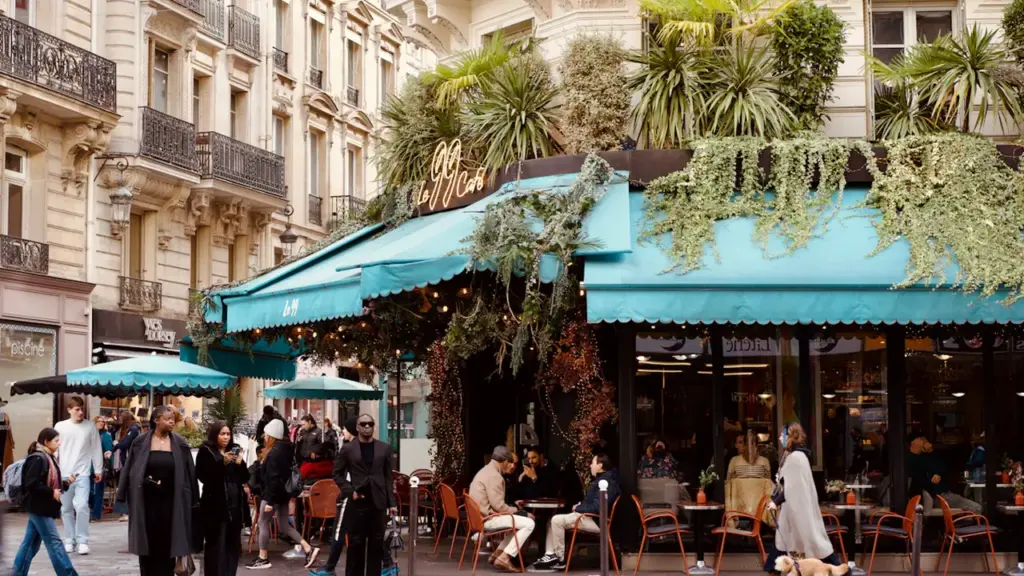 Une terrasse de café animée au cœur d'une ville française traditionnelle.
